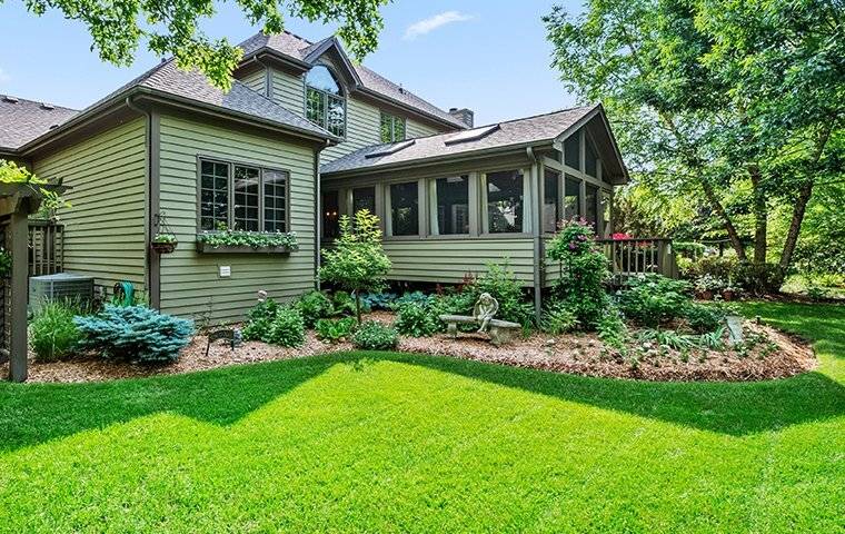 A Southlake, TX home with green grass and trees in the back yard, protected by effective Pest Control Solutions.