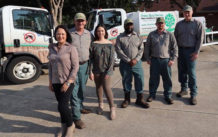 About Us: A group of people standing in front of a truck.