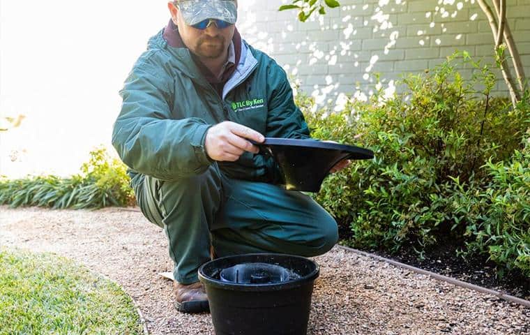 A man kneeling on the ground with a bucket, offering Mosquito Control services in Tarrant County.