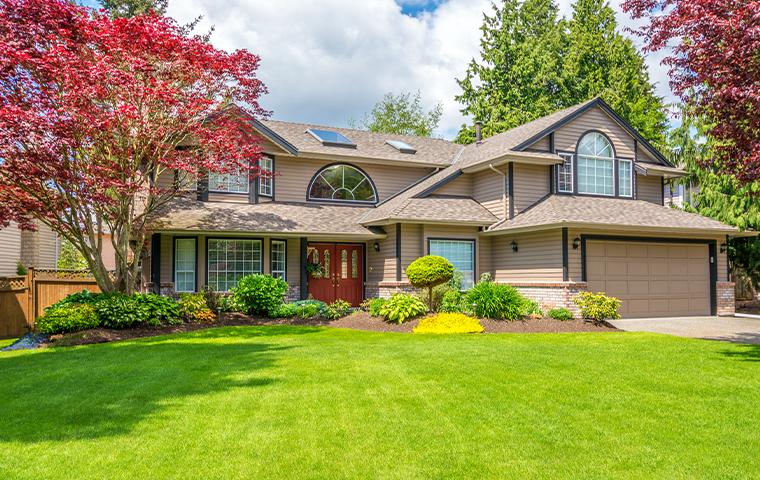 A beautiful home with green grass and Trees Hurt Too in the front yard.